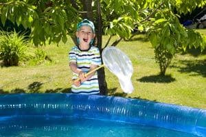 Kinderpool mit Rutsche Ratgeber: Junge mit Ketscher am Pool